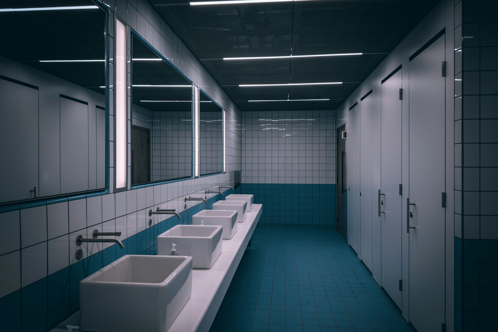 A dim bathroom lit only by a warm glow beneath the vanity